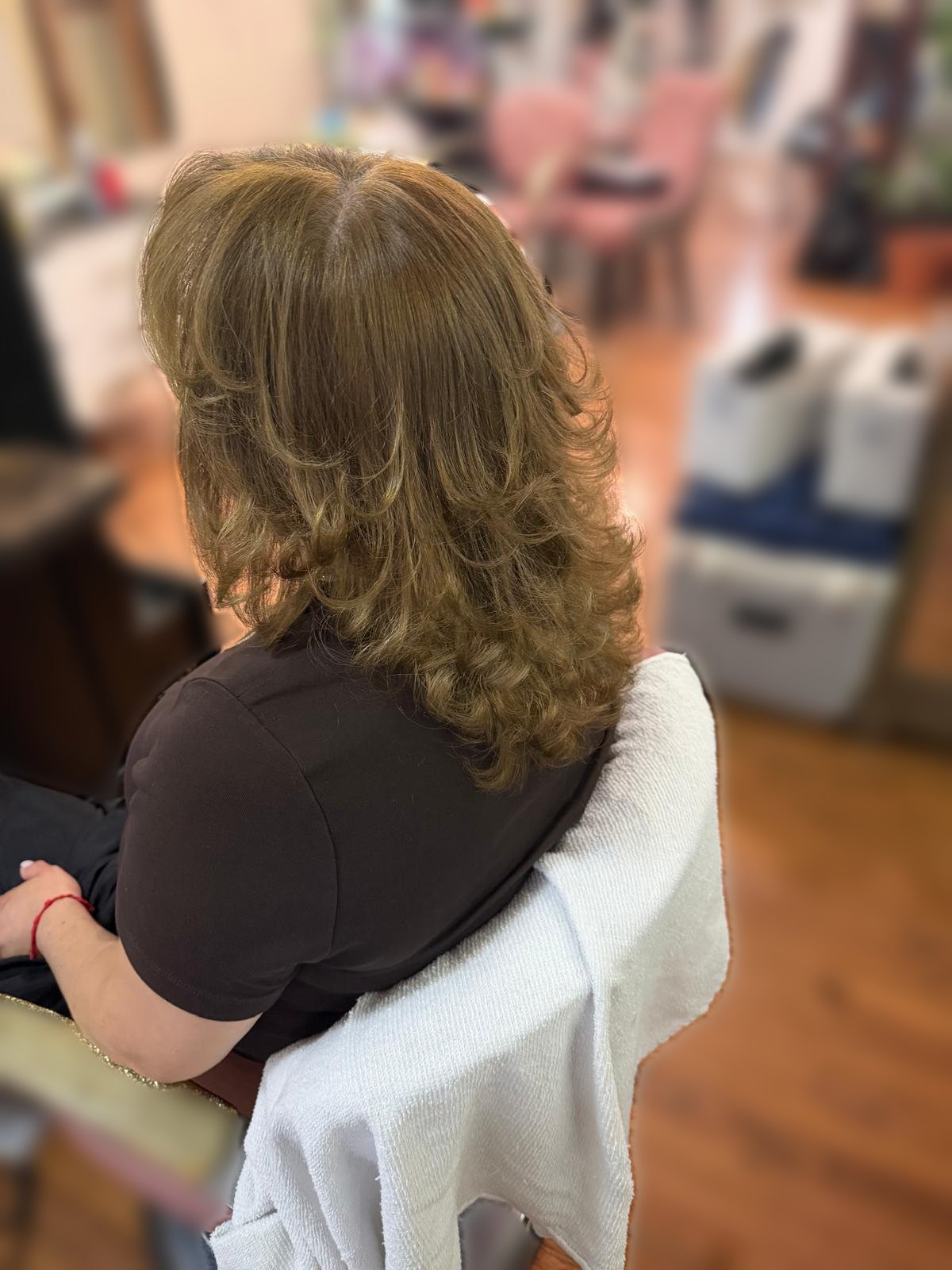 Long layered cut with a bouncy blowout in warm golden brown